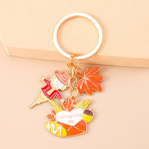 Detailed view of Thanksgiving keychain with scarecrow, maple leaf and envelope charms