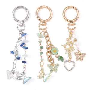 Tre eleganti portachiavi a farfalla con pietre turchesi, fiori di margherita e ciondolo a cuore