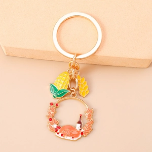 Detail of golden Thanksgiving keychain with corn, wheat, and turkey enamel charms