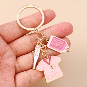 Detailed close-up of a pink nurse uniform and thermometer medical keychain held in hand