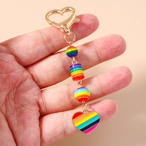 Porte-clés à perles arc-en-ciel avec breloque cœur et crochet doré sur fond orange doux