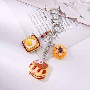 Detail of keychain with miniature resin toast, shop building and donut charms