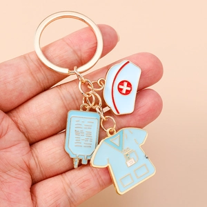 Detailed view of enamel nurse uniform and medical cap charms on a gold keychain