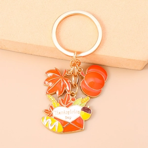 Detail of Thanksgiving keychain with gold metal pumpkin and orange maple leaf charms