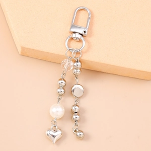 Dettaglio portachiavi a cuore argento con perle eleganti e sfere di metallo lucido