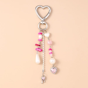 Detail of pink and white heart keychain with pearls, turquoise beads and rhinestones