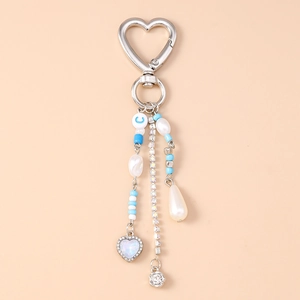 Detail of heart keychain with blue beads, sparkling rhinestone chain, and drop pearl