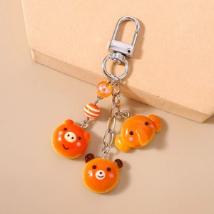 Detailed view of cute orange resin bear and pig charms on a silver keychain with beads