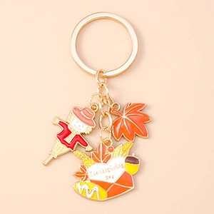 Detail of Thanksgiving keychain with scarecrow, maple leaf, and enamel heart envelope charm
