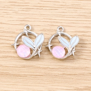 Detailed view of silver mermaid tail charms with pink crystal and blue enamel accents