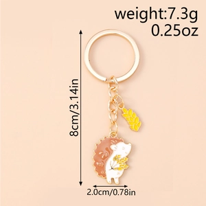 Detail of golden hedgehog keychain with wheat charm showing dimensions and weight