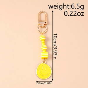 Close-up of yellow smiley face keychain with dimensions 10cm length and 6.5g weight