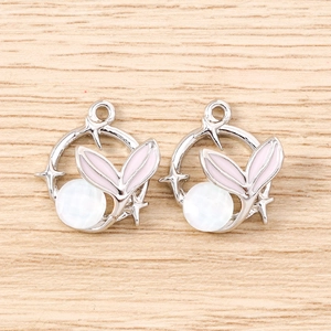 Detail view of silver fish tail pendants with pink enamel and round gemstone beads