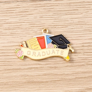 Détail macro du pendentif de remise de diplôme en émail avec livres et chapeau
