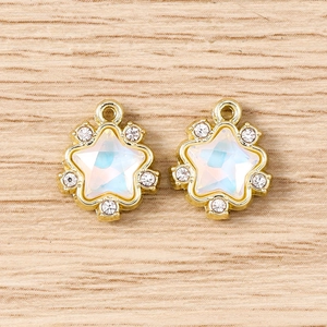 Detail of star charm with white opal stone and rhinestones on wood texture