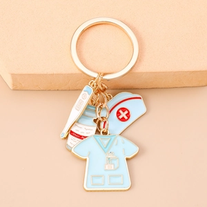 Close-up of nurse uniform and medical thermometer charms on gold metal keychain