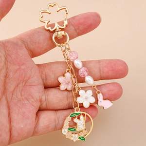 Macro detail of cherry blossom rabbit keychain with enamel petals and gold plating