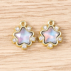 Detailed view of star-shaped gold charms featuring iridescent opal and sparkling rhinestones