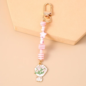 Gros plan détaillé d'un porte-clés à perles roses avec un pendentif tulipe doré