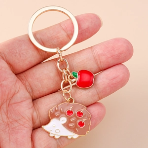 Cartoon hedgehog and red apple keychain with gold plating and enamel charms