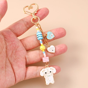 Porte-clés perlé charmant avec fermoir cœur et pendentif chiot blanc en émail