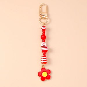 Vue macro du porte-clés à perles rouges avec pendentif tulipe et fermoir mousqueton doré