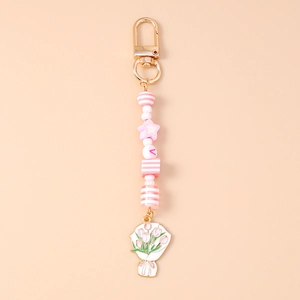 Détail du porte-clés perles avec fleur de tulipe et fermoir mousqueton doré élégant