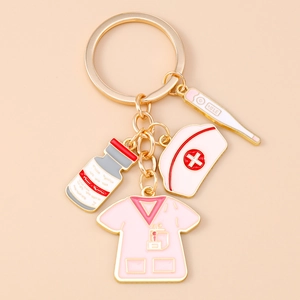 Detailed close-up of golden medical keychain featuring pink nurse uniform and enamel charms