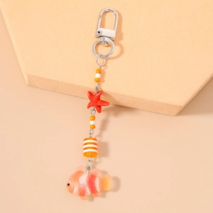 Detail of nautical keychain featuring a red starfish and orange striped clownfish pendant