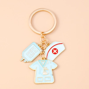 Detail of medical keychain with nurse hat, scrub, and IV bag enamel charms on gold ring
