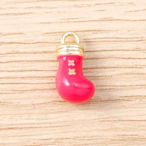 Detailed view of red Christmas boot pendant with gold stars on wooden background