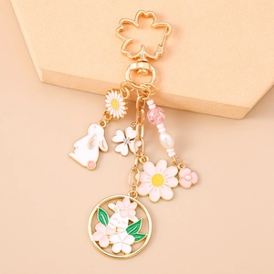 Detailed close-up of cherry blossom rabbit keychain with enamel charms and pearls