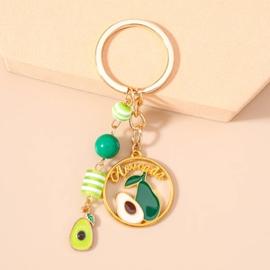 Detail of avocado keychain with gold hardware, green beads and engraved Avocado disc