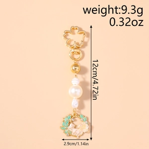 Detailed view of cat and flower wreath keychain with cherry blossom clasp and pearls