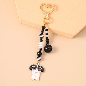Détail d'un porte-clés chien en émail avec fermoir coeur doré et perles élégantes