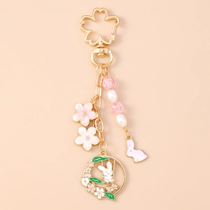 Detailed close-up of cherry blossom rabbit keychain with pink enamel and pearl beads