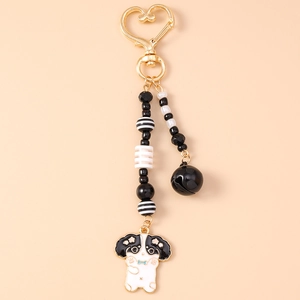 Détail du fermoir cœur doré et pendentif chien en émail avec des perles noires et blanches