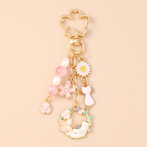 Detailed view of cherry blossom keychain with pink cat and floral wreath charms