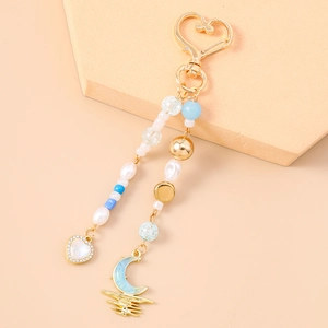 Detail von Perlen-Schlüsselanhänger mit Diamant-Herz und blauem Mond-Anhänger