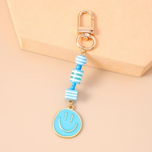 Detailed view of sky blue beaded keychain with striped geometric charms and gold smiley face
