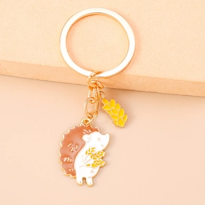 Detailed macro view of a cartoon hedgehog keychain with golden wheat stalk charm