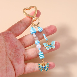 Portachiavi con farfalla blu con chiusura a cuore dorata e perline a righe
