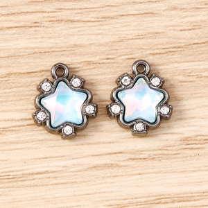 Detail showing two star-shaped pendants with opal stones and crystals on wooden background