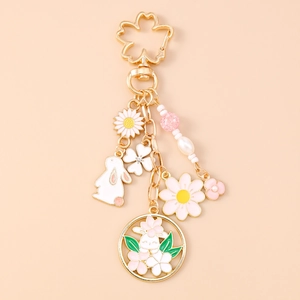 Detail of bunny and sakura flower keychain with gold-plated charms and faux pearl beads
