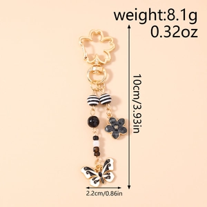 Detail of butterfly keychain with dimensions 10cm by 2.2cm and weight 8.1g markings