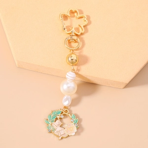 Floral cat keychain with cherry blossom clasp and pearls on an orange background
