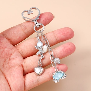 Dettaglio portachiavi a cuore argento con perline, nuvola di strass blu e accenti di perle