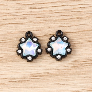 Detail of star-shaped pendants with black frame and rhinestones on wooden surface