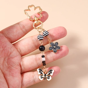 Handheld Tai Chi style keychain featuring black and white butterfly pendant and beads