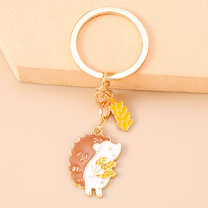 Macro detail of a golden hedgehog and wheat ear enamel keychain with high-quality plating